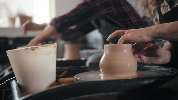 Potter Masterclass Man and Woman are Working with Pottery Wheel Making Pots During Master Class for