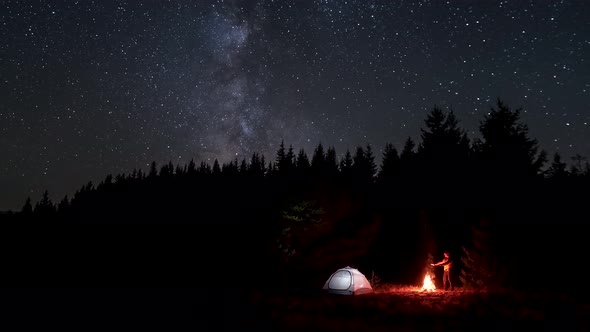 A Man Near a Fire at Night