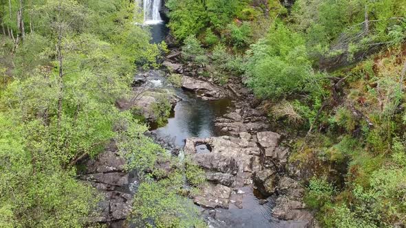 Cinematic revealing drone shot of scottish mountain river