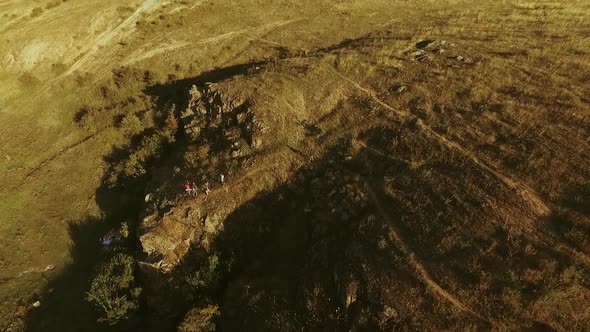 Panoramic View From Drone in Slowmotion with Tilt on Hilled Country with Group of Tourists Near