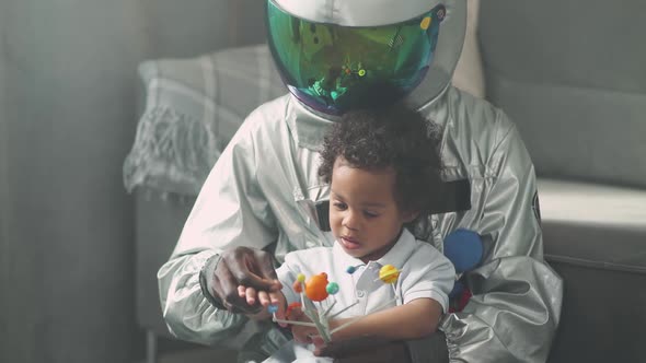 Afro American Father and Son Play in the Living Room at Home Man in an Usa Astronaut Costume Sitting