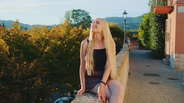 Blonde Young Woman Relaxing and Smiling in Sun Rays