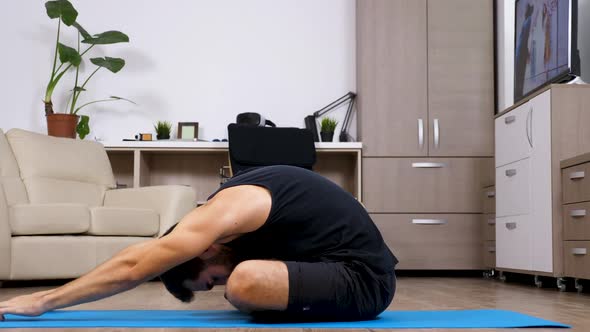 Man Doing Different Yoga Poses on a Blue Mat in His House