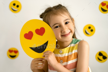 moji in her hands. World emoji day. Anthropomorphic smile Face. Emotions.