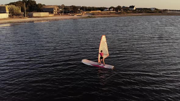 Aerial View of a Sportive Young Woman Learning To Fly a Windsurf Board