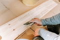 Installing wooden hardwood floor, detail on man hands holding wooden tile and spreading glue - PhotoDune Item for Sale