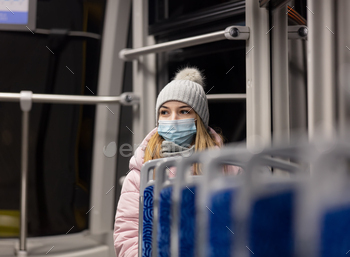 lonely girl in a face mask rides a tram at night in Pandemic time, Poland