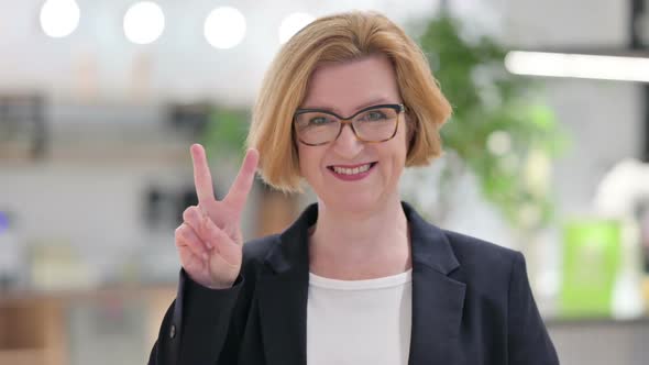 Portrait of Successful Old Businesswoman Showing Victory Sign