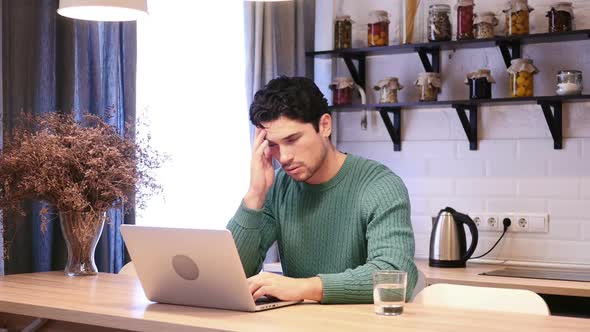 Headache Frustrated Tired Man Working on Laptop in Kitchen