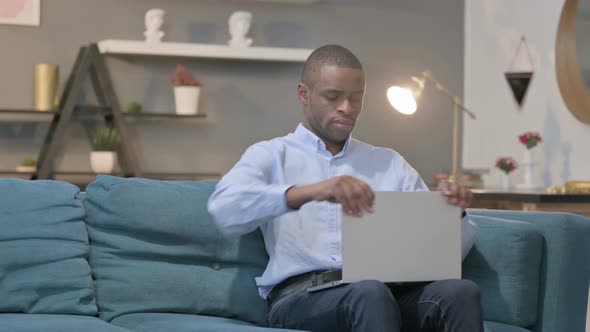 African Man Closing Laptop Standing Up Going Away
