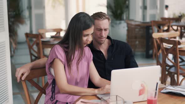 Freelancers, Man and Woman Work in Cafe, Use Laptop, Discuss Project