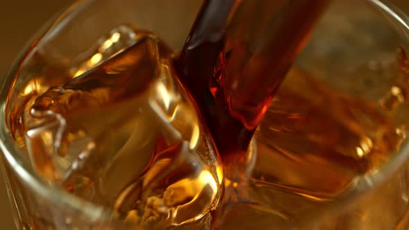 Super Slow Motion Macro Shot of Pouring Whiskey Into Glass with Ice Cubes at 1000Fps