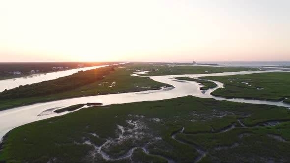 Sunrise flight over wetlands in Sunset Beach NC near the bridge and water tower