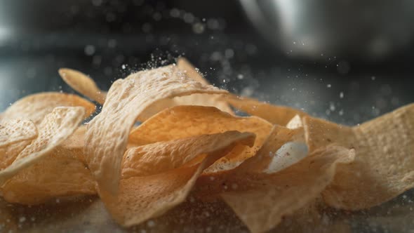 Adding salt on tortilla chips. Slow Motion.