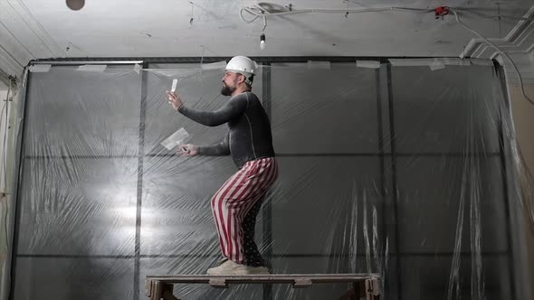 Fat Bearded Adult Man in Protective Helmet and USA Flag Print on Pants Remove Construction Whitewash