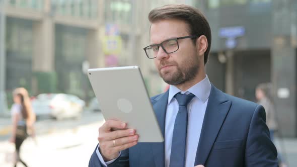 Businessman Celebrating on Tablet Outdoor