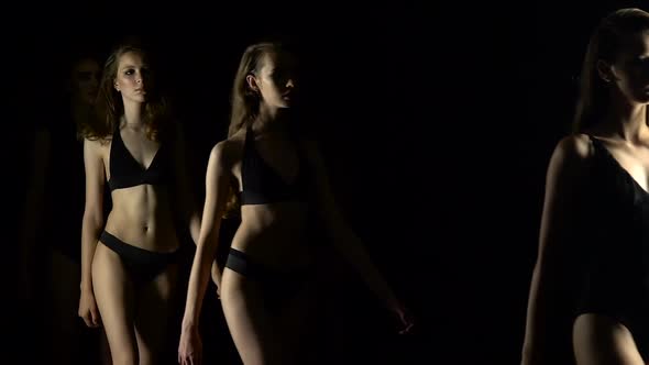 Fashion Shows in a Swimsuit. Black Background. Slow Motion
