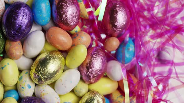 Rotating shot of colorful Easter candies on a bed of easter grass -