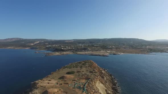 Aerial drone shot over Yeronisos sacred island off the coast of Cyprus as birds fly over the island