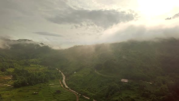 Aerial view of lush green tropical rain forest mountain with rain cloud cover during the rainy seaso