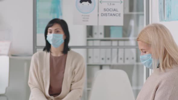 Sick Woman in Mask Coughing in Medical Office