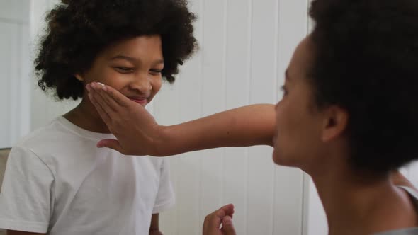 Mixed race mother and daughter having fun in bathroom