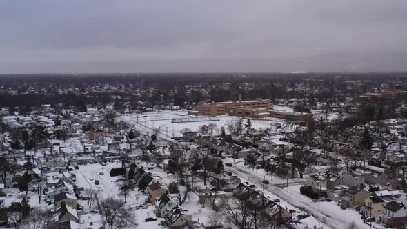 an aerial view of a suburban neighborhood in the morning, after a snow storm. The camera boom up the