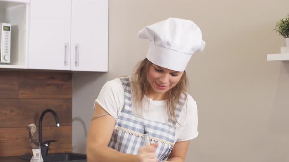 Caucasian Woman Making Dough with the Use of Mixer in Kitchen at Home