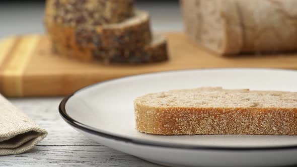 Female Hand Spreading Butter on Bread. Bread with Butter, Sliced Bread in the Background UHD