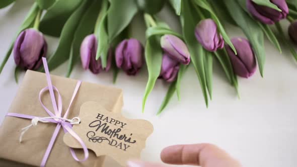 Small gift and purple tulips for Mother's Day