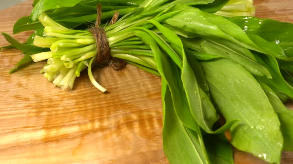 Wild garlic leaves on a wooden cutting board.