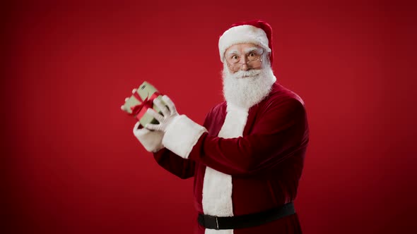 Portrait of Santa Claus Holding Christmas Present