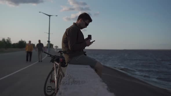 Traveler on Bicycle Stopped to Enjoy the View and Check Road Map on Smartphone to the Sea and Have