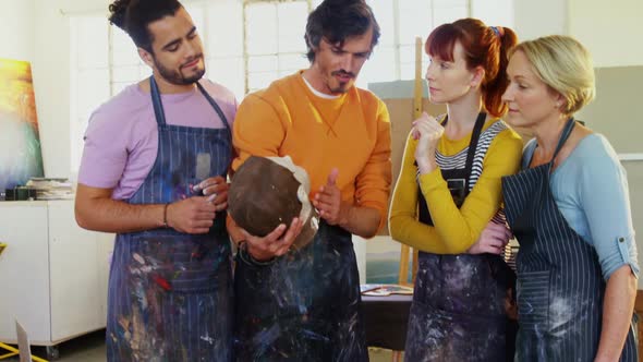 Drawing teacher assisting artists on ceramic sculpture 4k