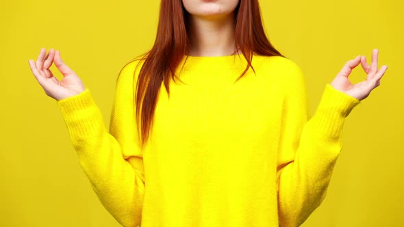 Unrecognizable Young Caucasian Woman Raising Hands and Meditating at Yellow Background