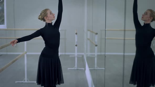 Slim Concentrated Young Woman Dancing Reflecting in Mirror in Dance Studio Indoors