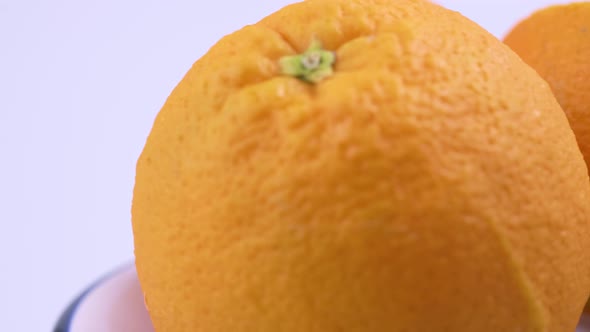 Close up fresh valencia orange sliced with white background shallow focus and slowly rotating.