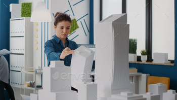 d maquette to plan urban project in office. Woman engineer working on construction design and layout to create real estate property.