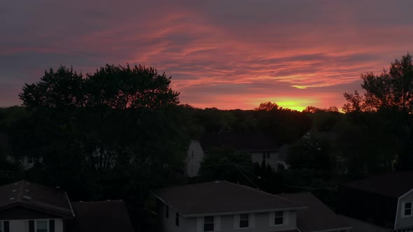 Aerial View of Rainbow at Sunset Flying Over Neighborhood of Houses Before the Storm