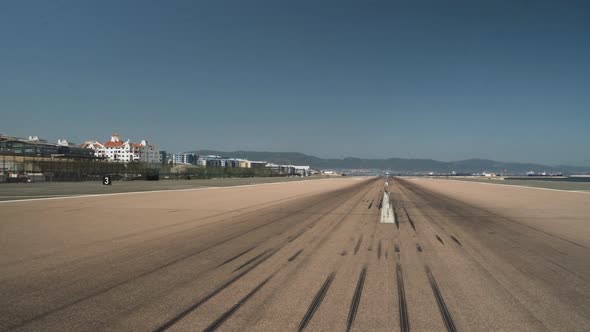 Empty runway tarmac with tire marks at Gibraltar airport, panning shot.