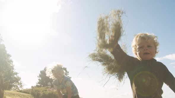 Toddler Throwing Meadow Grass To Camera