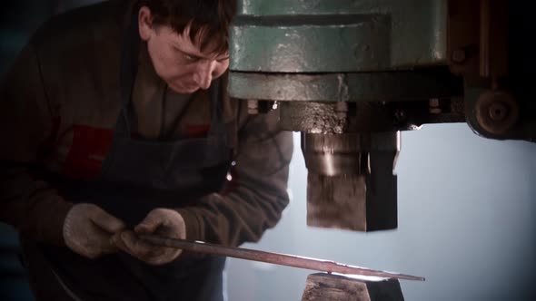 Blacksmith Workshop  a Man Shaping Heated Metal Using Automatic Pressing Machine