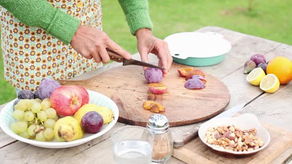 Woman cutting plum outdoors