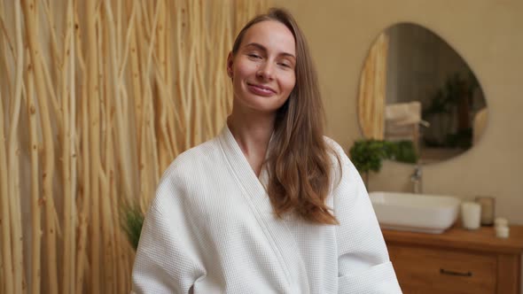 Young Woman in a Housecoat in the Bathroom Looking at the Camera