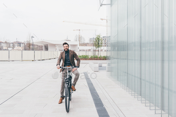Young businessman riding bike outdoor
