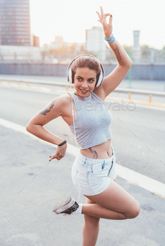 young beautiful multiethnic woman listening music with head phones