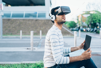 Young indian man outdoor enjoying immersive metaverse experience using 3D goggles