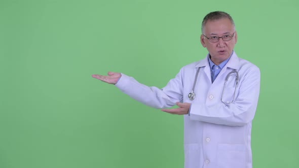 Stressed Mature Japanese Man Doctor Showing Something