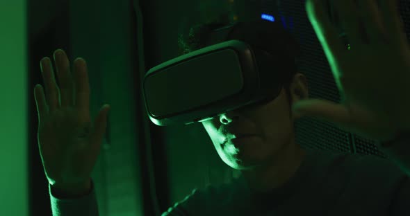 Close up of asian man wearing vr headset by computer servers