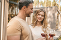 Young smiling couple holding glasses with wine and looking happy - PhotoDune Item for Sale